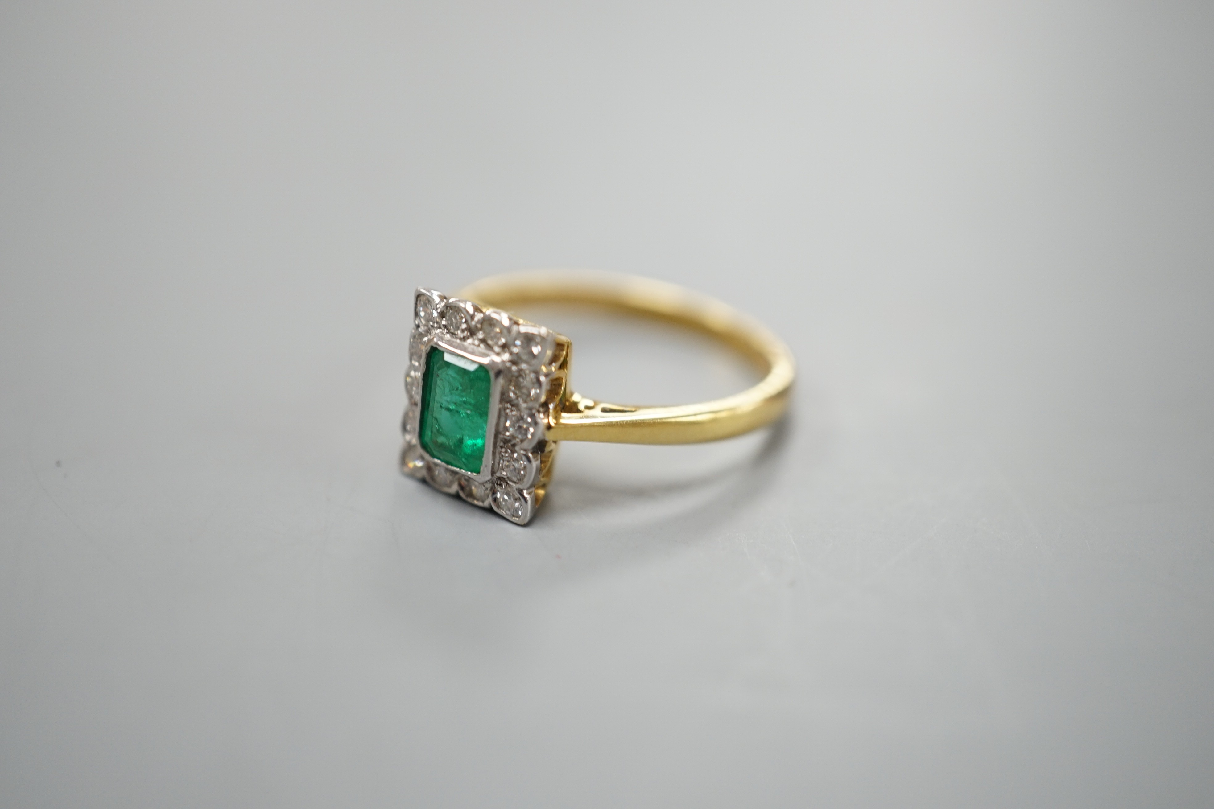 A modern 18ct gold, emerald and diamond set rectangular cluster ring, size N, gross weight 3.4 grams